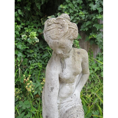 832 - A weathered reconstituted stone garden statue modelled as a Classical maiden on a reeded column plin... 