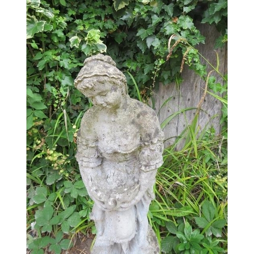 833 - A weathered reconstituted stone garden statue modelled as a girl holding a dove, on a reeded column ... 