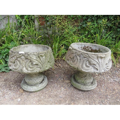 834 - A pair of weathered reconstituted stone garden urn planters having relief moulded acanthus leaf deco... 