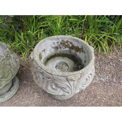 834 - A pair of weathered reconstituted stone garden urn planters having relief moulded acanthus leaf deco... 