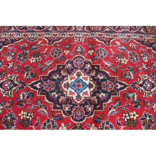 856 - A Persian Kashan rug.  Central pattern on blue foliage on a red ground. 150cm x 100cm (approx) Condi... 