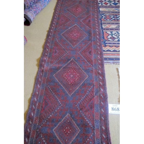 868 - A Meshwani runner, repeat central pattern on a burgundy ground. Good condition. 246cm x 58cm (approx... 