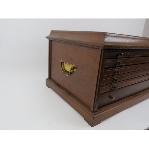 130 - A modern oak coin collector’s cabinet. Comprising of six lined drawers with carry handles to the sid... 