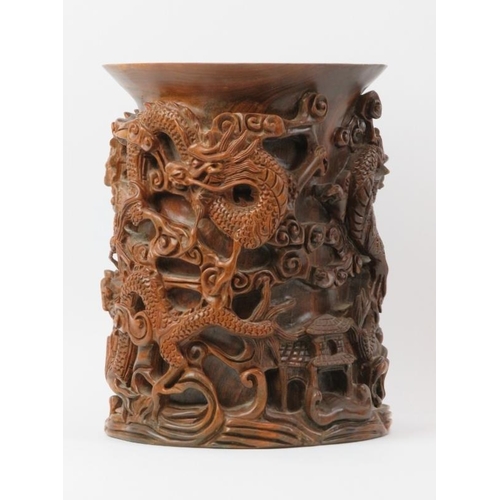 135 - A large Chinese carved wood brush pot, 20th century. Profusely decorated in high relief depicting dr... 