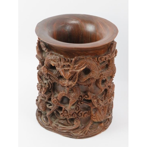 135 - A large Chinese carved wood brush pot, 20th century. Profusely decorated in high relief depicting dr... 