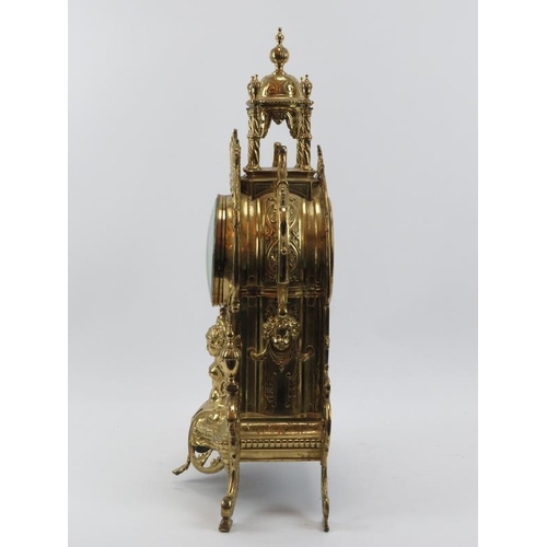 139 - A large Baroque style brassed metal mantel clock, late 19th/early 20th century. Keys and pendulum in... 