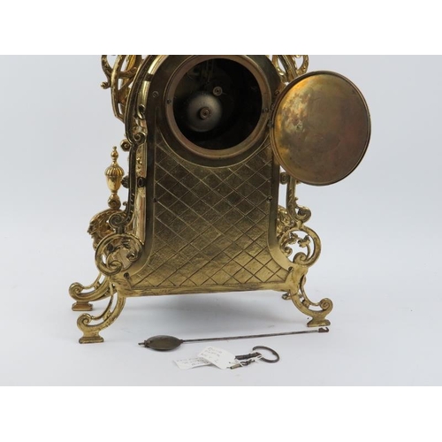 139 - A large Baroque style brassed metal mantel clock, late 19th/early 20th century. Keys and pendulum in... 