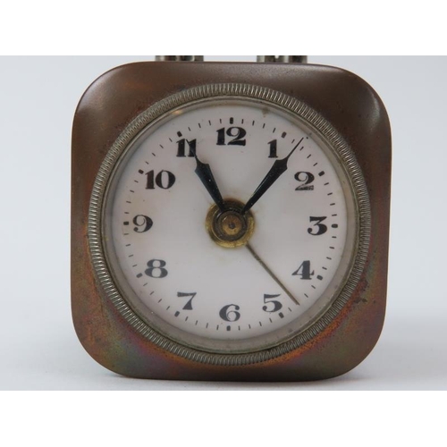 174 - A miniature brass portable desktop wind up alarm clock, early 20th century. With white enamelled dia... 