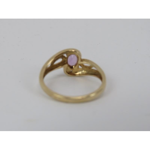 183 - A 9ct yellow gold diamond and amethyst ring. With a central claw set amethyst enclosed by an illusio... 