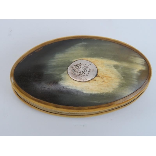 193 - A late Georgian carved horn snuff box. Of elliptical form, the cover mounted with a white metal plaq... 