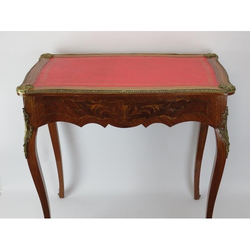 221 - A French 18th century style brass mounted marquetry inlaid tulip wood side table. With a gilt tooled... 