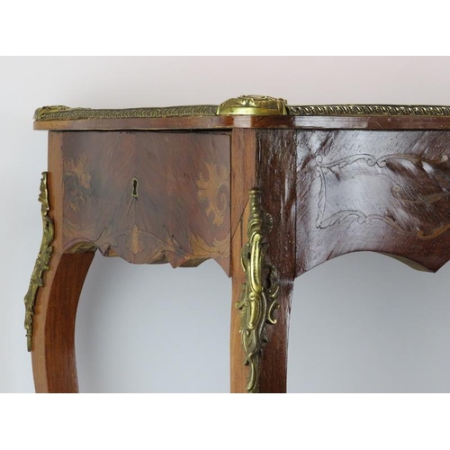 221 - A French 18th century style brass mounted marquetry inlaid tulip wood side table. With a gilt tooled... 