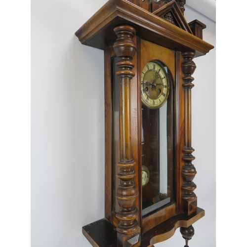 251 - A large mahogany wall clock, late 19th/early 20th century. Probably Austrian or German. Key and pend... 