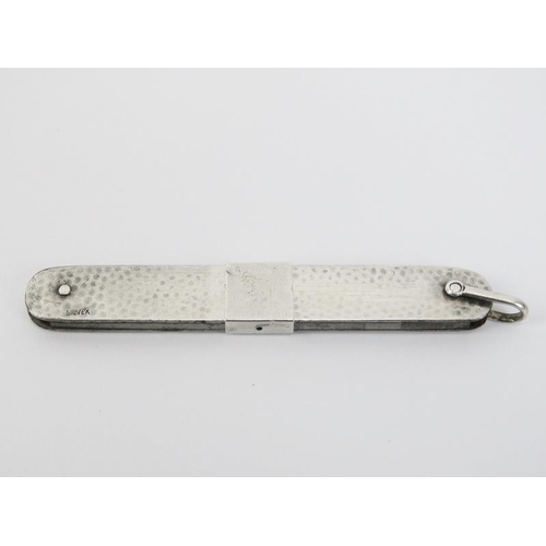 32 - A white metal spot hammered fruit knife, probably early 20th century. With unusual sliding double st... 