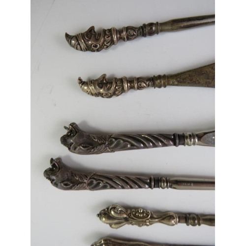 377 - A collection of silver mounted button hooks and shoe horns including Mr Punch and leopard's heads.