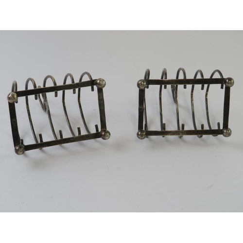 399 - A pair of Edwardian silver four slice toast racks on ball feet. Hallmarked for Birmingham 1902/03, m... 