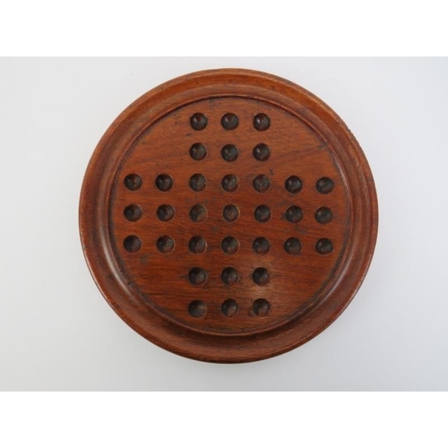 4 - A turned oak Solitaire board with glass marbles, late 19th/early 20th century. Board: 25 cm diameter... 