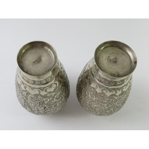 403 - A pair of Eastern white metal vases with chased decoration, height 11.5cm. Gross weight 230 grams