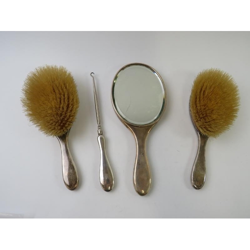 438 - An early 20th century Mappin & Webb three piece silver backed vanity set and matching button hook, e... 