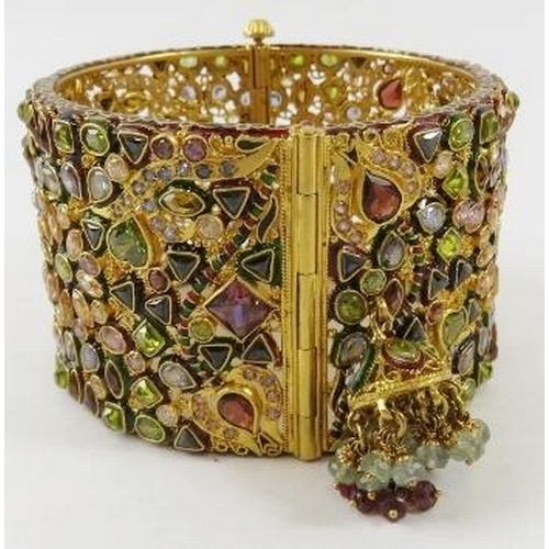 446 - A decorative 22ct gold Indian wide hinged bangle, of openwork design all over set with facet cut sem... 