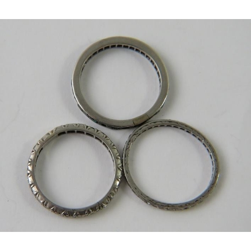 457 - A precious white metal and diamond full eternity ring, testing platinum; and two other similar etern... 