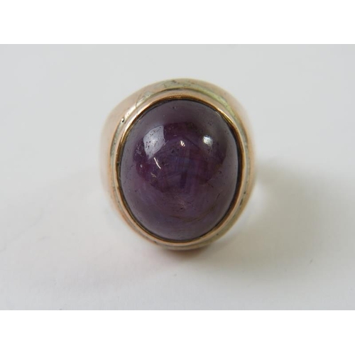 466 - A large purple star sapphire cabochon in heavy precious rose metal bezel setting, testing as 9ct, 17... 