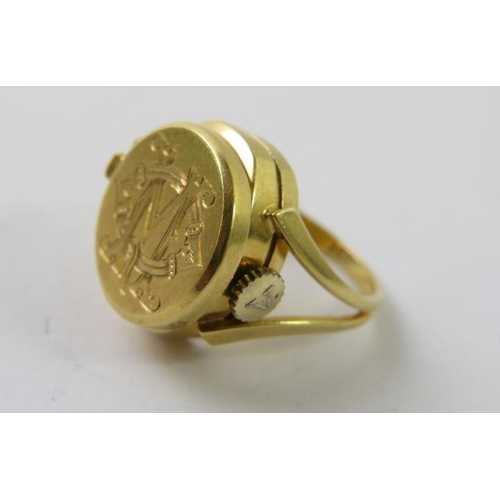 468 - An 18ct yellow gold novelty watch ring, the monogram engraved hinged circular lid opening to reveal ... 