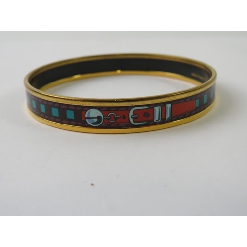 488 - HERMES: A  narrow belt printed enamel and yellow metal plated circular bangle 71mm diameter x 10mm h... 