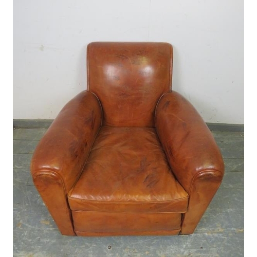 707 - A vintage low and deep club armchair, upholstered in tan leather with brass studs, on block feet. 
H... 