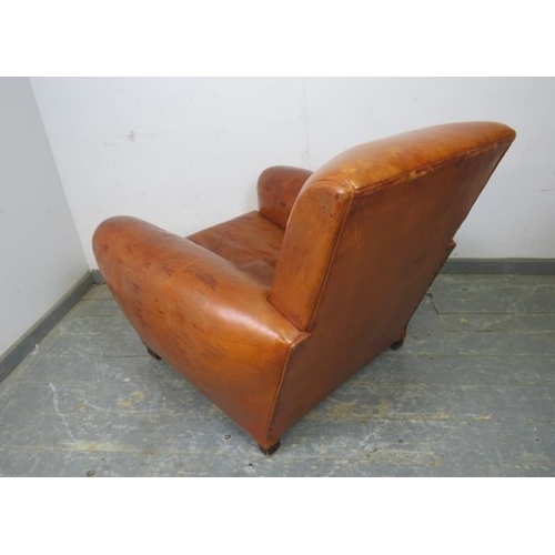 707 - A vintage low and deep club armchair, upholstered in tan leather with brass studs, on block feet. 
H... 