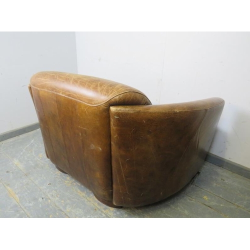 708 - A small two-seater sofa in the aviator style, upholstered in distressed brown leather, on block feet... 