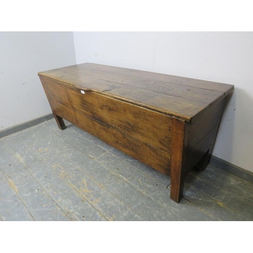 712 - An 18th century French oak dough bin of exceptionally large proportions, the hinged lid with shaped ... 