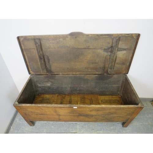 712 - An 18th century French oak dough bin of exceptionally large proportions, the hinged lid with shaped ... 