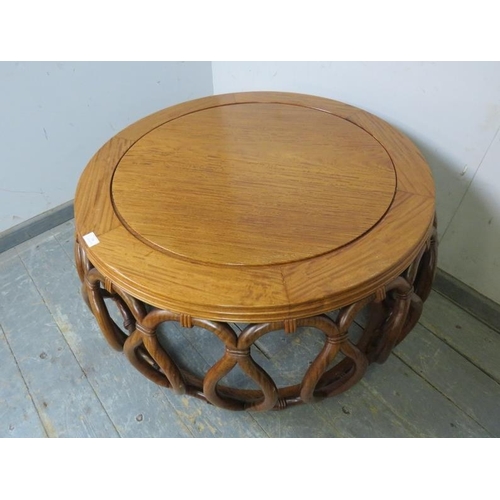 722 - A vintage low Chinese hardwood barrel coffee table, the circular top on an intricately carved base s... 