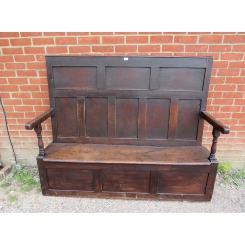 724 - An 18th century high back oak settle, the panelled back joined to a box settle base with internal st... 