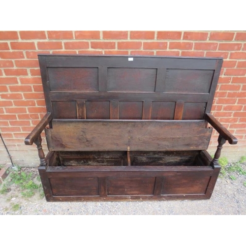 724 - An 18th century high back oak settle, the panelled back joined to a box settle base with internal st... 