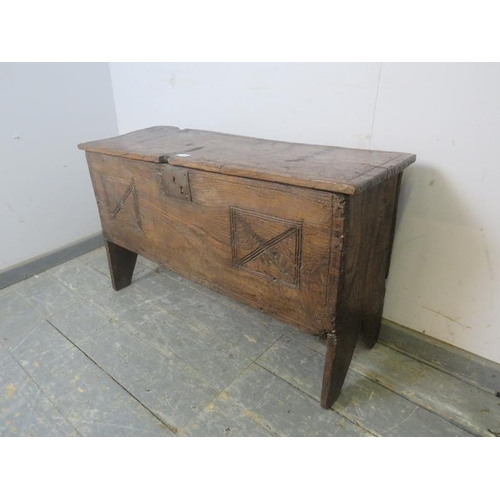 729 - A 17th century elm six-plank coffer, having carved geometric decoration to front, on stile supports.... 