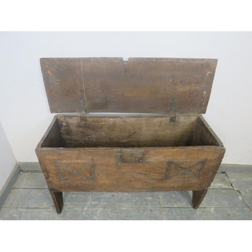 729 - A 17th century elm six-plank coffer, having carved geometric decoration to front, on stile supports.... 