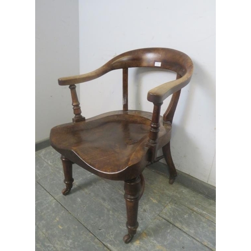 730 - A 19th Century walnut captain's chair, the shaped back above a deeply sculpted seat, on turned suppo... 