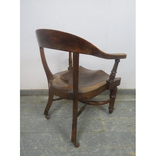 730 - A 19th Century walnut captain's chair, the shaped back above a deeply sculpted seat, on turned suppo... 