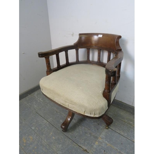 731 - An early 20th Century oak captain's swivel desk chair, recovered in neutral material, on four shaped... 