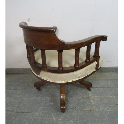 731 - An early 20th Century oak captain's swivel desk chair, recovered in neutral material, on four shaped... 