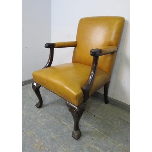 735 - An antique mahogany library chair in the 18th century taste, upholstered in mustard leather with bra... 