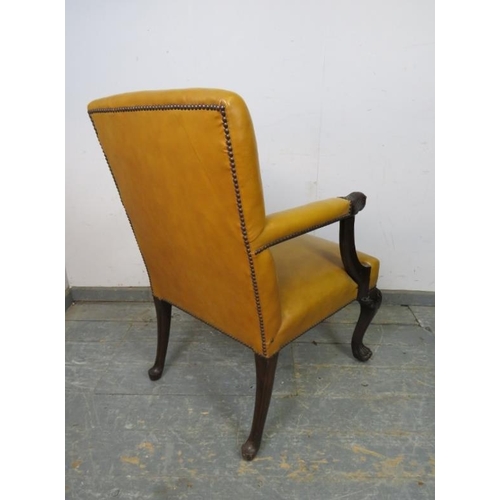 735 - An antique mahogany library chair in the 18th century taste, upholstered in mustard leather with bra... 