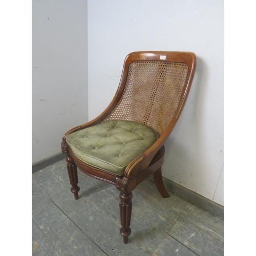 736 - A Victorian mahogany bergere library chair, the raked back with curved sides, on fluted front suppor... 