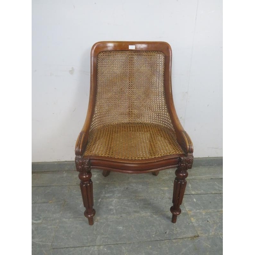 736 - A Victorian mahogany bergere library chair, the raked back with curved sides, on fluted front suppor... 