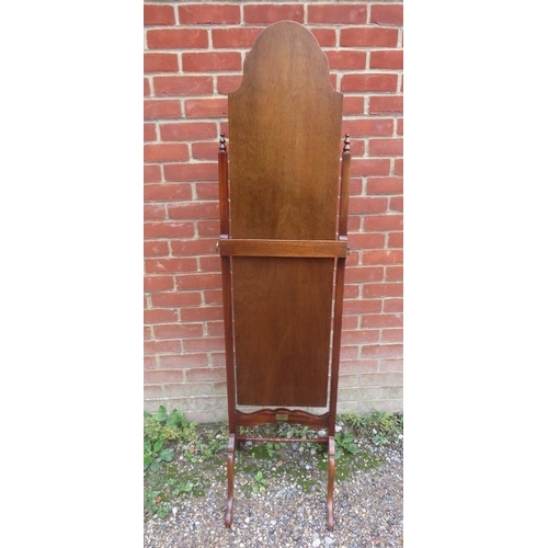 745 - A vintage bevelled cheval mirror within a shaped walnut surround, the stand with turned finials and ... 