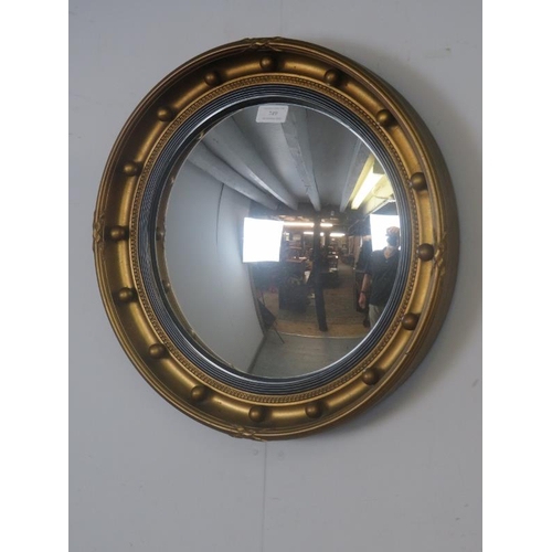 749 - A vintage convex butler's mirror in the Regency taste, having a reeded ebonised border and gilt gess... 