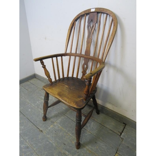 751 - A 19th Century elm hoop-back Windsor chair, having shaped and pierced splat, on turned supports with... 