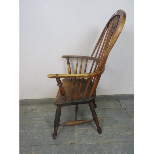 751 - A 19th Century elm hoop-back Windsor chair, having shaped and pierced splat, on turned supports with... 